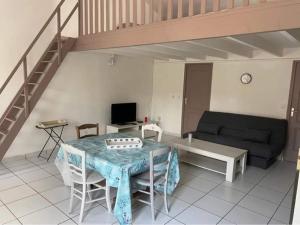 a living room with a table and a couch at Gîte le verger in Soulignonne