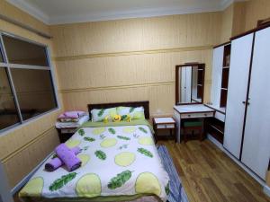 a small bedroom with a bed and a table at Teluk Batik Beach Apart ment Lumut Sitiawan NO POOL in Lumut +1 photo