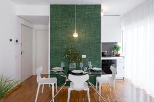 a dining room with a table and chairs and a christmas tree at Appartamenti Vela Milano centro con garage in Milan