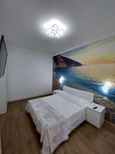 um quarto com uma cama e uma pintura do oceano em Villa Virlan em Numana