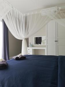 a bedroom with a blue bed with a canopy at Pool Villa Nita in Ban Na Klang