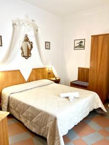 a bedroom with a bed with a mirror on the wall at Piccolo Hotel Etruria in Siena