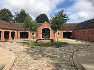a courtyard with a fountain in front of a brick building at Unique Countryside Retreat, walking distance to the Three Choirs Vineyard & Restaurant, Gloucestershire in Newent