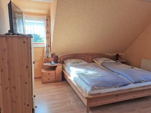 sypialnia z drewnianym łóżkiem i oknem w obiekcie Biene's Bärenstube w mieście Elze