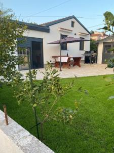 een huis met een picknicktafel in de tuin bij The House in Medulin