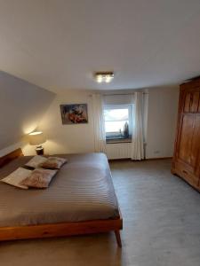 Un dormitorio con una cama grande y una ventana en Landhof Osterdeich, en Emmelsbüll-Horsbüll