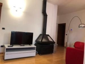 ein Wohnzimmer mit einem Herd und einem TV in der Unterkunft Appartamento A casa di Tamy in Fabriano