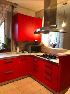 a kitchen with red cabinets and a stove at Appartamento A casa di Tamy in Fabriano