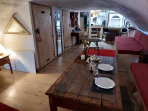 ein Wohnzimmer mit einem Holztisch mit Tellern darauf in der Unterkunft Studio atypique rue de Turin (ancienne étable de village) in Breil-sur-Roya