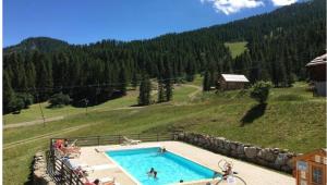 a swimming pool in the middle of a mountain at Appartement Montagne Puy Saint Vincent 1800 - Résidence Dame Blanche 3 étoiles in Puy-Saint-Vincent