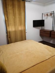 um quarto com uma cama e uma televisão de ecrã plano em Golden Sunset 3 em Njivice