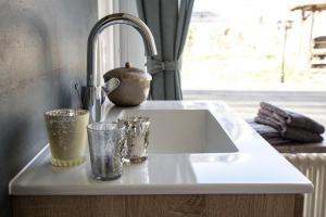 a kitchen counter with a sink and glasses on it at Ferienwohnung Viventum34 in Vallendar +8 photos