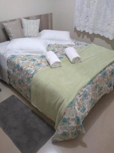 a bed with two towels on top of it at Casa e Flat Conforto Gramado in Gramado