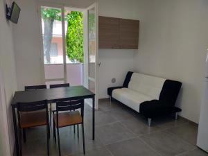 sala de estar con mesa y sofá en BILOCALE Villa Lara en Cesenatico