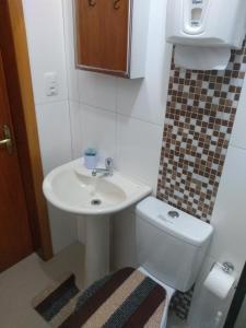 a small bathroom with a sink and a toilet at Casa e Flat Conforto Gramado in Gramado +38 photos