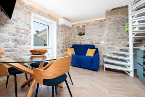 a dining room with a blue couch and a stone wall at Casa Bellavista Sea View in Rovinj