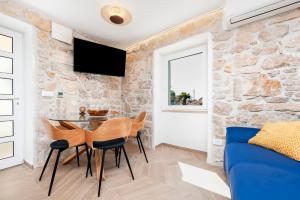a living room with a blue couch and a stone wall at Casa Bellavista Sea View in Rovinj