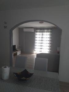een woonkamer met een tafel en stoelen en een raam bij Apartment Darinka in Šibenik