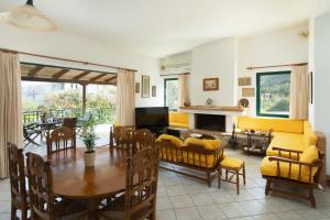 a living room with a table and yellow furniture at Eleni's House Cozy 2-Bedroom House with Garden in Monemvasia