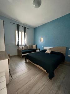 a blue bedroom with a bed and a couch at Carrubella Santa Zita in Licata