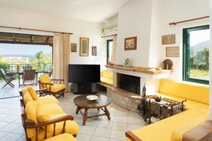 a living room with yellow furniture and a fireplace at Eleni's House Cozy 2-Bedroom House with Garden in Monemvasia