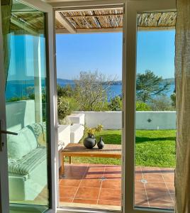 a sliding glass door leading to a patio with a table at Casa de oro Alma in Sozopol