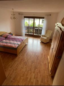 ein Schlafzimmer mit einem Bett, einem Stuhl und einem Fenster in der Unterkunft Ferienwohnung Wolf in Seebruck