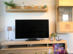 a flat screen tv sitting on a wooden entertainment center at Sommerwind in Eutin