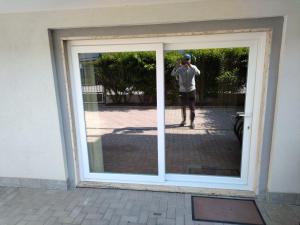 Un uomo che scatta una foto di un riflesso in una finestra di casa di Enzo:relax a 2 passi dal mare a Camaiore