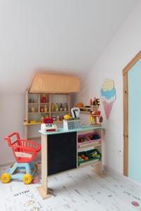 a toy kitchen with a desk and a red chair at WILLA MAGNOLIA - Apartamenty i Pokoje - ROWERY, POKÓJ ZABAW, KAWA Z EKSPRESU in Jantar