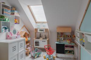 a childs play room with a toy kitchen and a window at WILLA MAGNOLIA - Apartamenty i Pokoje - ROWERY, POKÓJ ZABAW, KAWA Z EKSPRESU in Jantar