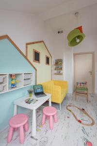 a doll house living room with a table and stools at WILLA MAGNOLIA - Apartamenty i Pokoje - ROWERY, POKÓJ ZABAW, KAWA Z EKSPRESU in Jantar