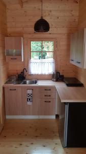 a kitchen with a sink and a window in a cabin at Zacisze Śniardwy in Nowe Guty