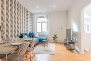 a living room with a blue couch and a table at Plumeria - Grand Appartement 75m2 - Au calme avec Jardin - Idéal Famille ou Groupe de Travailleurs - Parking Public Gratuit - 2 Chambres - 4 Lits séparés in Metz