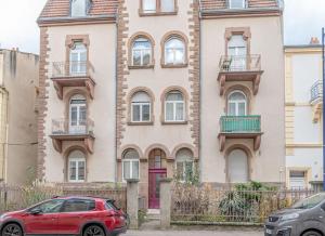 a red car parked in front of a building at Plumeria - Grand Appartement 75m2 - Au calme avec Jardin - Idéal Famille ou Groupe de Travailleurs - Parking Public Gratuit - 2 Chambres - 4 Lits séparés in Metz