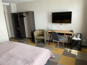 a hotel room with a bed and a desk and a television at Gästehaus Bendsieferhof in Monschau