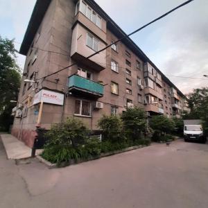 un immeuble d'appartements avec un panneau sur son côté dans l'établissement Центр города., à Almaty