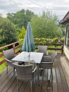 a table and chairs with an umbrella on a deck at Private Holiday home in calm site in Wootton Bridge