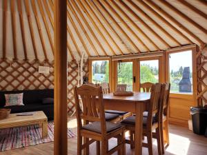a dining room with a table and chairs in a yurt at Fichtel-Jurte - Optional mit Hot Tub in Hohenberg an der Eger