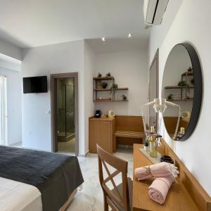 1 dormitorio con cama y escritorio con espejo en Sarantis Hotel, en Chaniotis