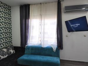 um quarto com um sofá azul em frente a uma janela em cosy home em Rabat