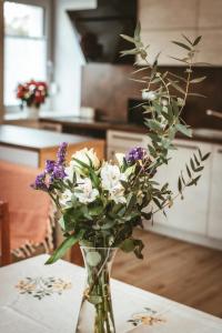 a vase filled with flowers on a table at Apartma Moser in Podnanos