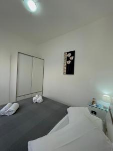 a white room with a bed and a mirror at Appartamenti Le Castella in Le Castella