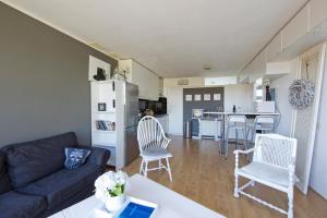 a living room with a couch and chairs and a kitchen at Chapeau in Zandvoort