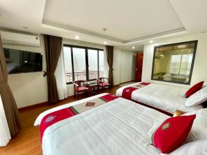 ein Hotelzimmer mit 2 Betten, einem Tisch und Stühlen in der Unterkunft Sapa Star Hotel in Sa Pa