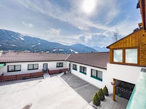 a house with a courtyard and mountains in the background at Sylpaulerhof Aparthotel in Sankt Michael im Lungau