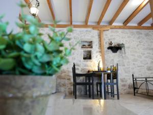 a dining room with a table and chairs and a plant at Το Λαϊνάκι by Fox Tale Guest House in Fternón +29 photos