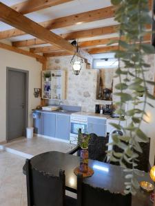 a kitchen with blue cabinets and a table with chairs at Το Λαϊνάκι by Fox Tale Guest House in Fternón
