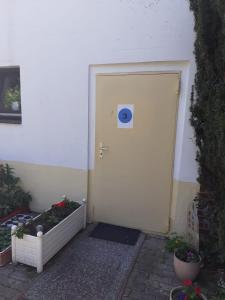 a white door with a sign on it next to some plants at Apartment 3 nähe Barmestedt - Elmshorn in Bokholt-Hanredder