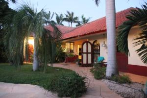 a house with palm trees in front of it at B&B Villa Zomerland in Julianadorp